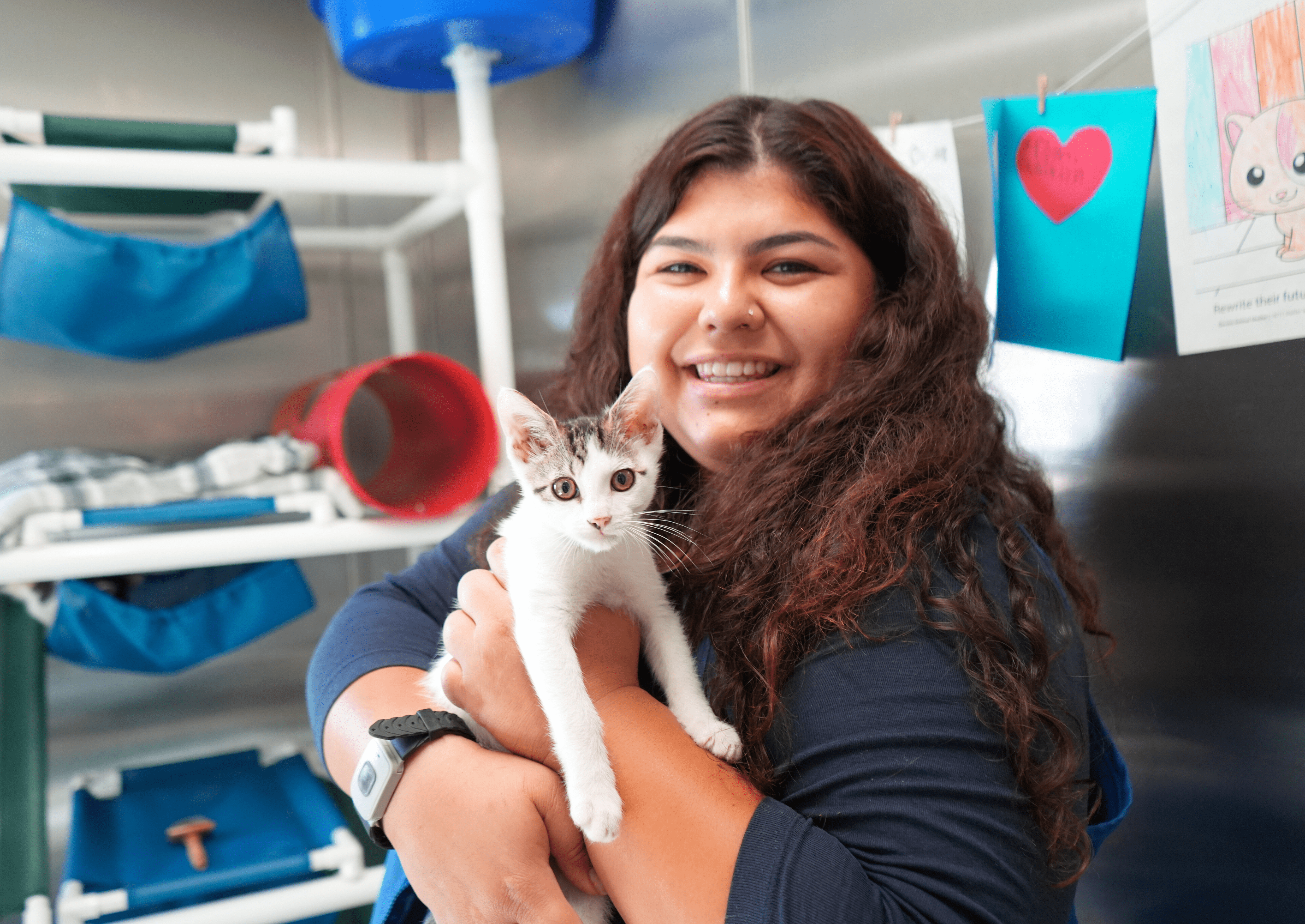 Enrichment Specialist smiling with a kitten