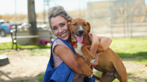 Women smiling while hugging a puppy